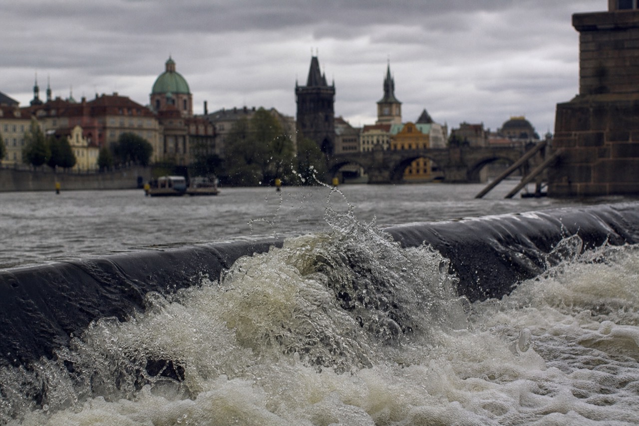 The Vltava river curving through central Prague past the embankment and bridges at golden hour