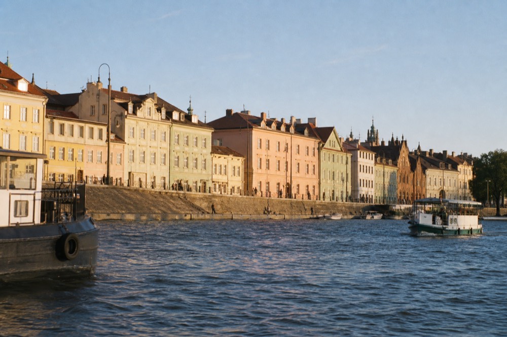 Pastel Old Town facades along the embankment seen low from the water in bright daylight